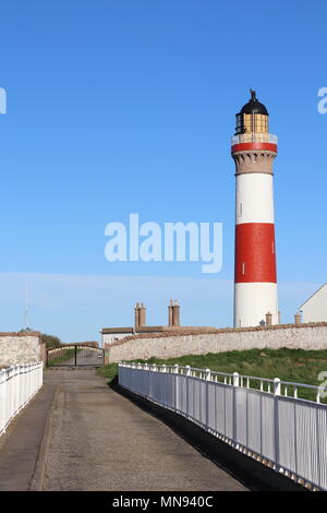 Phare rouge et blanc, contre le ciel bleu, blanc avec garde-corps sur le pont en premier plan Banque D'Images