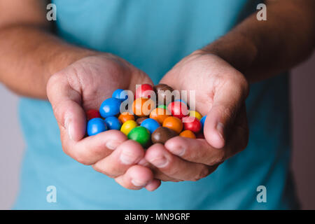 Homme de race blanche holding bonbons colorés Banque D'Images