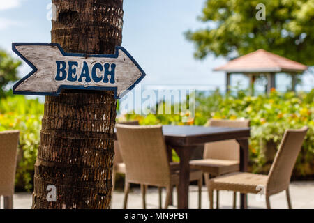 Café en plein air avec un panneau de flèche sur la plage, sur l'océan sur l'arrière-plan. Nusa Dua, Bali, Indonésie Banque D'Images