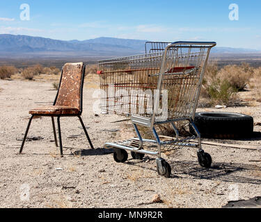 Une vieille chaise, panier, pneu, une vie encore peu probable de l'autre côté de la Californie regroupement's Wonder Valley, dans le désert de Mojave, Élevé, USA. Banque D'Images