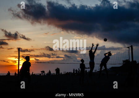 Plage de Berawa (Pantai Berawa) au coucher du soleil. Silhouettes de gens jouer au volley-ball. Canggu, Bali, Indonésie. Banque D'Images