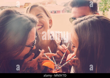 2 couples de gars à boire un verre sur la terrasse rouge avec 4 pailles bleu et blanc. Tous les voisins de rire passer un moment fun gratuitement. Filtre Vintage Banque D'Images