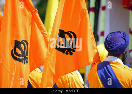 Drapeaux orange avec le sikhisme appelé symbole Khanda et un homme à turban bleu Banque D'Images