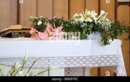 Fleurs en pot dans l'église sur un autel saint Banque D'Images