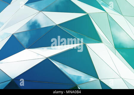 Triangle polygonal façade en verre de bâtiment moderne. Ciel nuageux reflète dans verre Banque D'Images