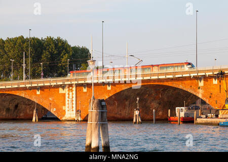 Le tramway traversant le Ponte della Libertà reliant Venise et Mestre centre historique sur la lagune de Venise au coucher du soleil, Venise, Vénétie, Italie. Transp Banque D'Images