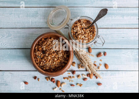 Le muesli dans un bol avec une cuillère, les fruits séchés et les noix. Petit déjeuner sain. Vue de dessus Banque D'Images