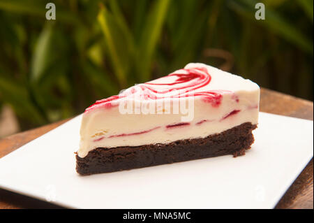 Morceau de glace d'ondulation framboise sur un brownie au chocolat Banque D'Images
