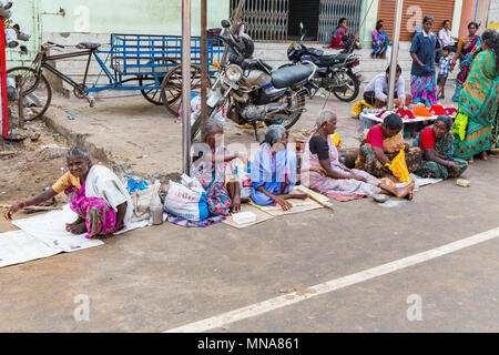 Groupe de pèlerins dévots non identifiés, Sadhus vêtus de vêtements orange, assis dans la rue, sur la route, en attente de l'alimentation. Pas de maison, résidence outd Banque D'Images