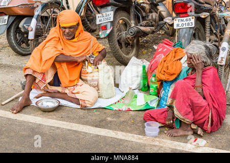 Groupe de pèlerins dévots non identifiés, Sadhus vêtus de vêtements orange, assis dans la rue, sur la route, en attente de l'alimentation. Pas de maison, résidence outd Banque D'Images