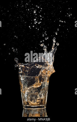 Shot de whiskey isolé avec splash sur fond noir Banque D'Images