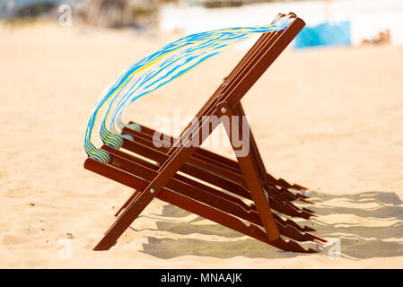 Rangée de chaise vacant toiles soufflant et tourbillonnent dans le vent sur une plage. Banque D'Images