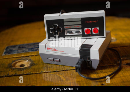 Une Nintendo Classic Mini "Nintendo Entertainment System" console de jeux vidéo avec un contrôleur branché sur elle. L'après Kyoto société de jeux vidéo Nintendo terminé c'est l'année de retour avec une valeur de 9 milliards de dollars de recettes après un glorieux 2017 notamment avec le lancement de la console de Nintendo l'hybride, l'interrupteur mini retro vintage de jeux vidéo comme la Nintendo Entertainment System et Super Nintendo ainsi que son téléphone mobile jeux vidéo. Nintendo va aussi accueillir son nouveau président Shuntaro Furukawa au mois de juin 2018. Banque D'Images