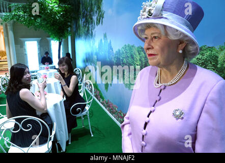 Shanghai, Chine. 15 mai, 2018. Les touristes ont pause thé à côté de la figure de cire de la reine Elizabeth II, au musée de cire Madame Tussauds à Shanghai, la Chine orientale, le 15 mai 2018. Une semaine culturelle britannique a ouvert ses portes au Musée de mardi. Crédit : Chen Fei/Xinhua/Alamy Live News Banque D'Images