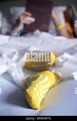 14 mai 2018 - Philadelphia, PA, USA : un patient de l'hôpital remplit les formulaires sur un presse-papiers au lit. Banque D'Images