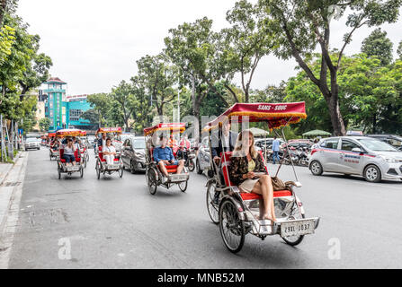 Les vélos-pousse, les vendeurs de rue et tours de Hanoï Vietnam vie Banque D'Images