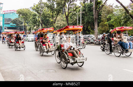 Les vélos-pousse, les vendeurs de rue et tours de Hanoï Vietnam vie Banque D'Images