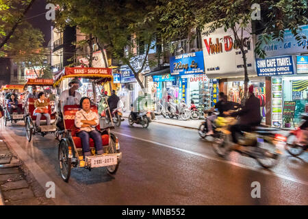 Les vélos-pousse, les vendeurs de rue et tours de Hanoï Vietnam vie Banque D'Images