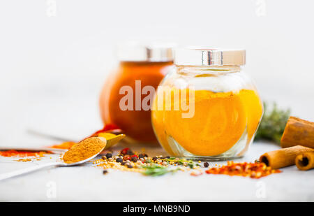 Les épices dans des bocaux avec le curcuma et le paprika. Condiments aromatiques Banque D'Images