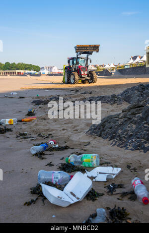 Litière de premier plan sur la plage de sable tranquille station touristique au début par un beau matin d'été ensoleillé en cours de nettoyage par tracteur avec fond surf rake. Banque D'Images