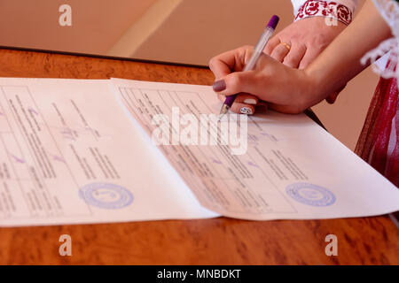 Belle jeune couple pendant le mariage met les signatures qui certifie le mariage Banque D'Images