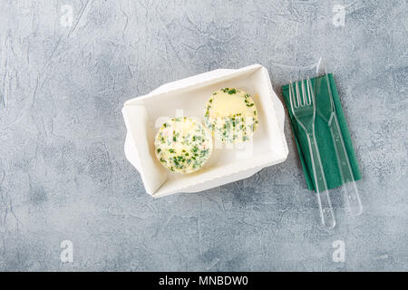 Muffins d'oeufs de poisson et de verts dans un papier fort sur un fond gris. Livraison d'aliments sains. Plats à emporter pour le régime. Vue d'en haut. Banque D'Images