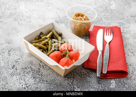 Les haricots cuits, les poissons en sauce boules et Pommes au four dans lunch sur un fond gris. Livraison d'aliments sains. Banque D'Images