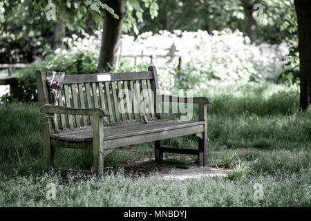 Memorail banc dans le parc avec des fleurs'' lié au moyen d'une corde Banque D'Images