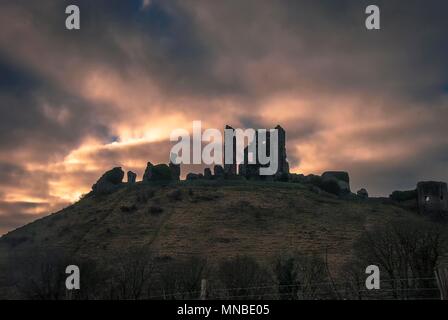 Le soleil se lève derrière les ruines du château de Corfe, dans le Dorset, UK Banque D'Images