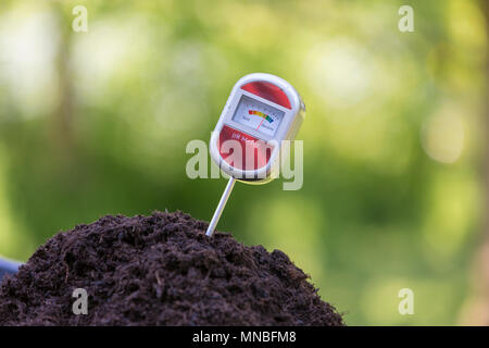 À l'aide d'un pH du sol Test appareil de contrôle de l'acidité du compost de jardin. Banque D'Images