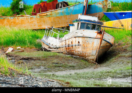 Un vieux bateau pourri abandonné se trouve dans un champ boueux qui semblent être un cimetière pour les vieux bateaux. Vu depuis le sentier de randonnée le long de la baie Kachemak . Banque D'Images