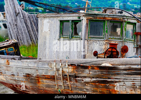 Bateau abandonné en décomposition dans les champs vu de sentier de randonnée le long des rives de la baie Kachemak Homer en Alaska. Banque D'Images