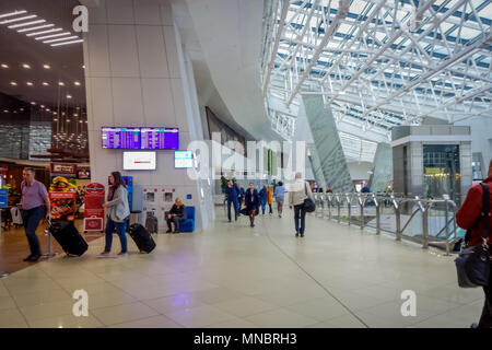 MINSK, BELARUS - 01 MAI 2018 : les touristes non identifiés à marcher avec leurs bagages et de regarder un écran de départ, situé à l'intérieur de l'aéroport de Minsk Banque D'Images