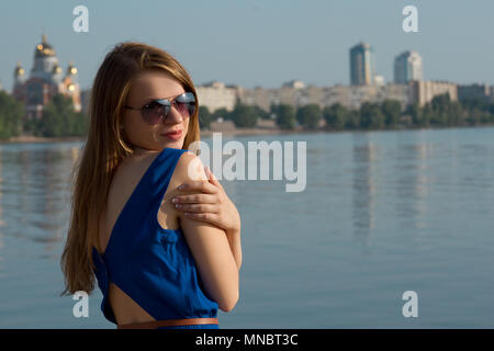 Jeune fille dans une robe bleue sur le fond de la rivière. L'Ukraine. Kiev. Obolon Banque D'Images