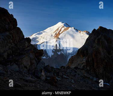 Reconnaissant le mont enneigé Sovetov entre les roches d'ossature au lever du soleil dans les montagnes Shan Tyan au Kazakhstan Banque D'Images