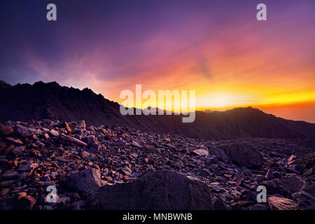 Orange et violet magnifique coucher de soleil dans les montagnes en silhouette au Kazakhstan Banque D'Images