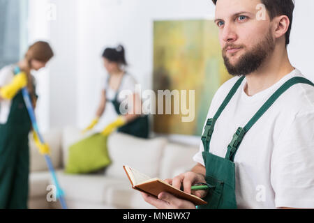 Beau jeune homme en uniforme de nettoyage nouveau travail de planification Banque D'Images