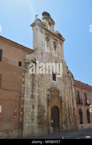 Belle façade de l'église de l'Université d'Alcala de Henares avec un nid de cigognes dans son ancien clocher. Billet d'architecture historique. 5 mai Banque D'Images