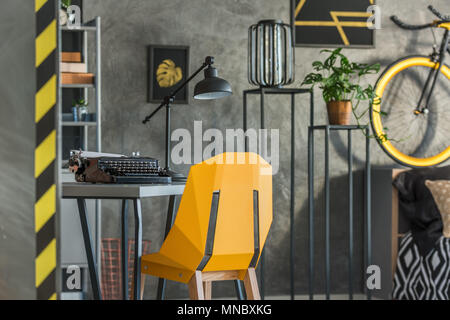 Accueil Gris bureau avec chaise jaune et vieille machine à écrire Banque D'Images