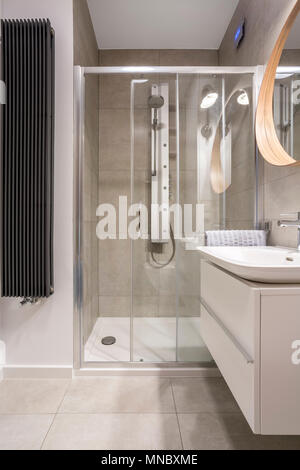 La lumière salle de bains avec cabine de douche et carreaux gris Banque D'Images