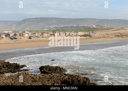 Bateaux de pêche marocaines tiré vers le haut sur la plage et juste à l'extérieur des cabanes de pêche Tagazoute Maroc Banque D'Images