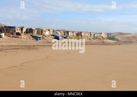 Bateaux de pêche marocaines tiré vers le haut sur la plage et juste à l'extérieur des cabanes de pêche Tagazoute Maroc Banque D'Images