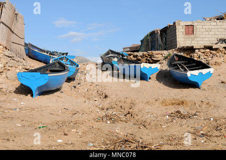 Bateaux de pêche marocaines tiré vers le haut sur la plage et juste à l'extérieur des cabanes de pêche Tagazoute Maroc Banque D'Images