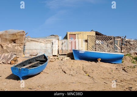 Bateaux de pêche marocaines tiré vers le haut sur la plage et juste à l'extérieur des cabanes de pêche Tagazoute Maroc Banque D'Images