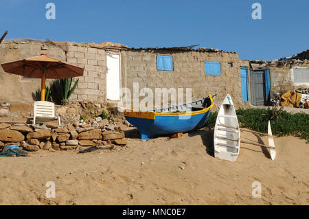 Bateaux de pêche marocaines tiré vers le haut sur la plage et juste à l'extérieur des cabanes de pêche Tagazoute Maroc Banque D'Images