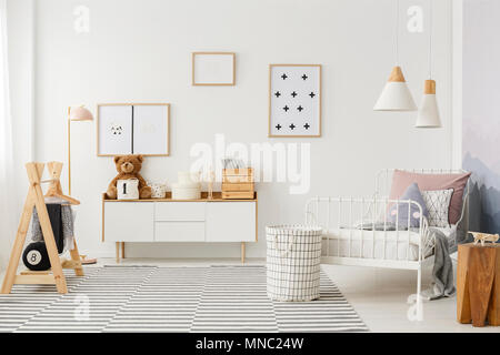 Le second chambre lumineuse, mobilier en bois, des accessoires et des affiches sur un mur blanc Banque D'Images