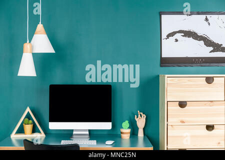 Close-up of computer monitor sur 24 avec clavier et souris contre le mur vert dans home office interior Banque D'Images