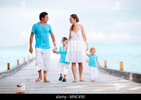 Belle jeune famille de quatre personnes à marcher le long de la jetée en bois Banque D'Images