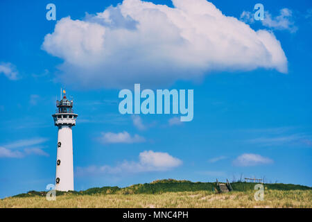 Phare blanc à Egmond aan Zee aux Pays-Bas avec ciel bleu et un grand nuage blanc Banque D'Images