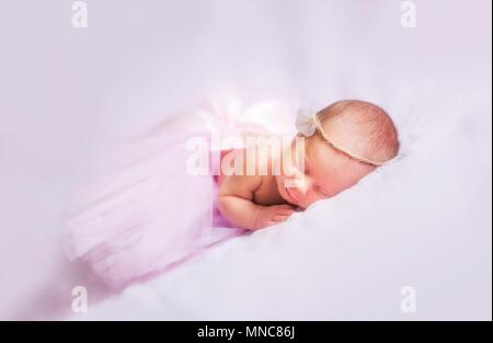 Belle fille robe ballerine en nouveau-né portrait. Girl sleeping on bed. Banque D'Images